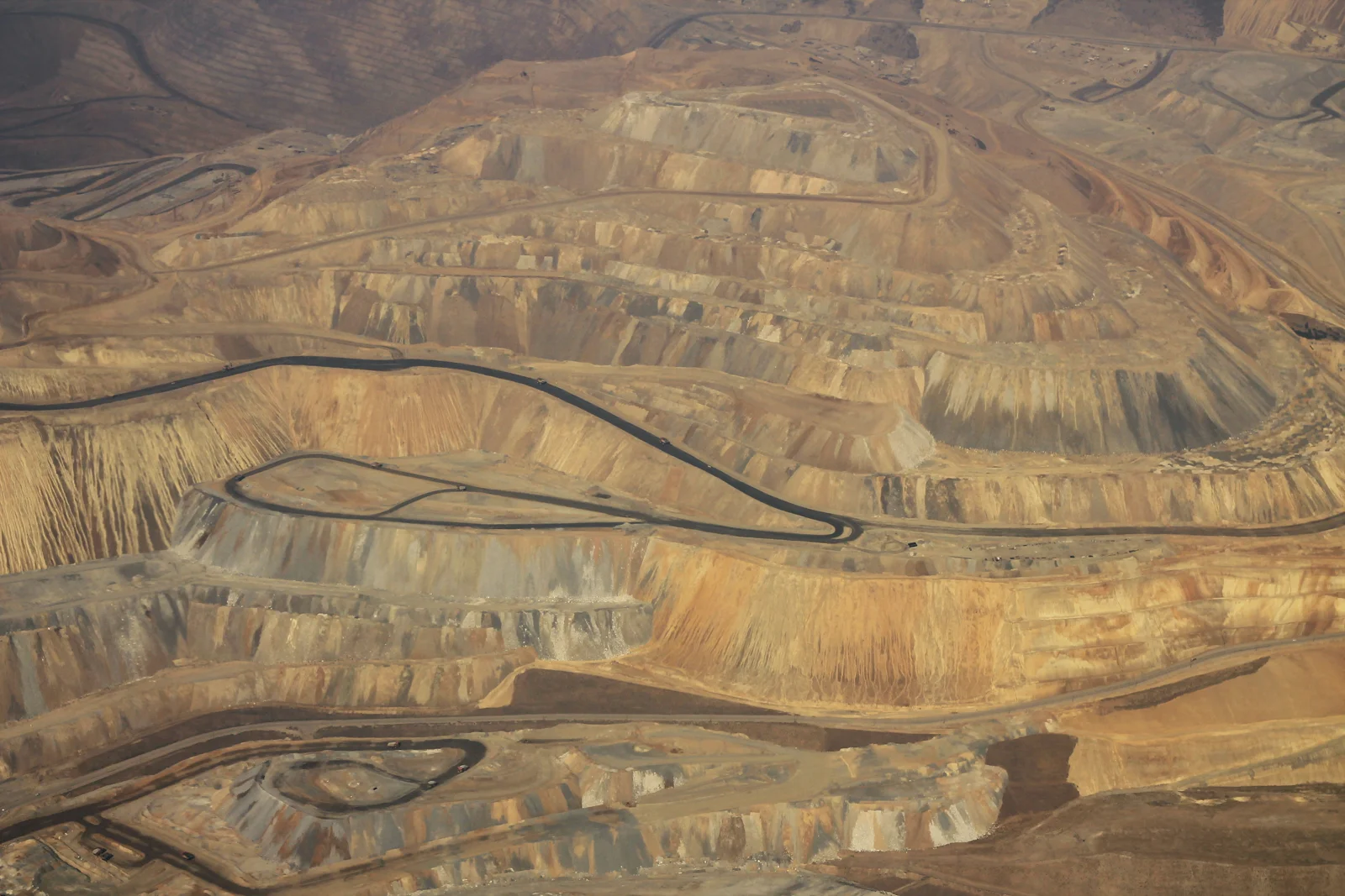 Aerial view of golden terraces and winding haul roads in the Kennecott copper mine, Utah